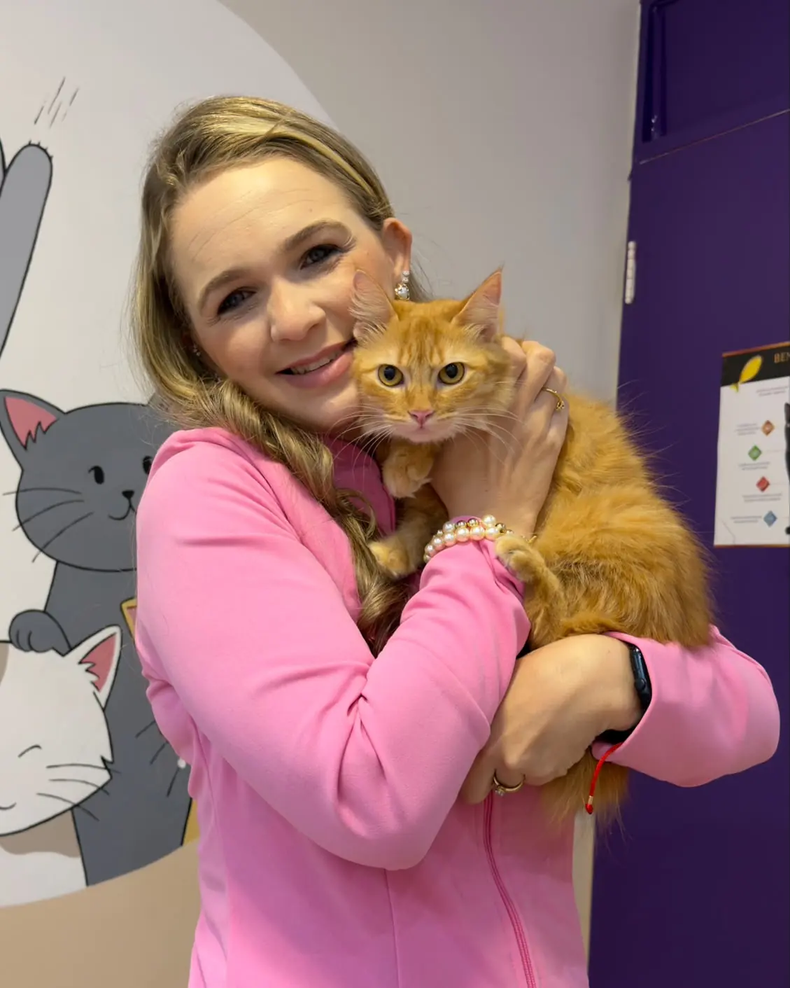 Veterinária da Felinnus segurando um gato laranja no colo